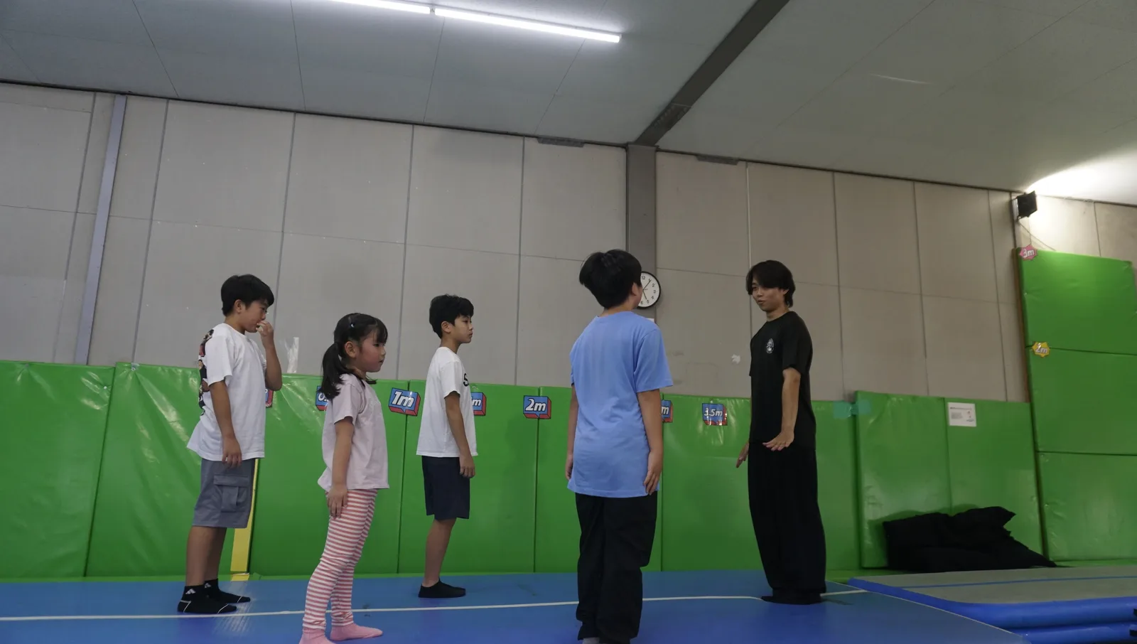 インストラクターの説明を聞くスクールの子どもたち