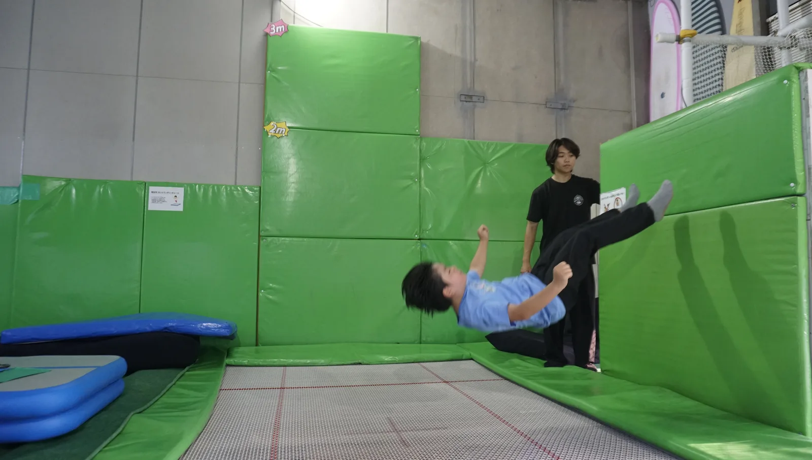 インストラクターが見守る中で技に挑戦する男の子